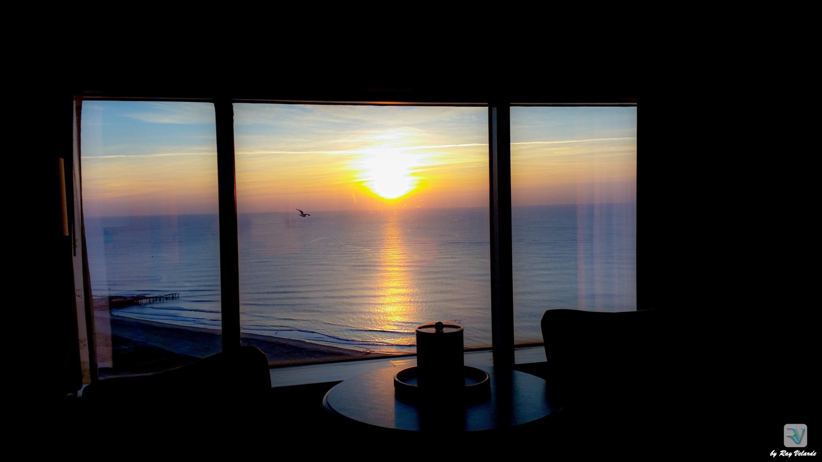 Atlantic sunrise viewed through floor-to-ceiling windows above the beach