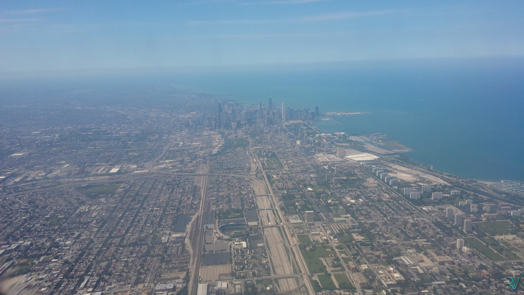 Aerial view of Chicago stretching toward Lake Michigan beneath blue haze