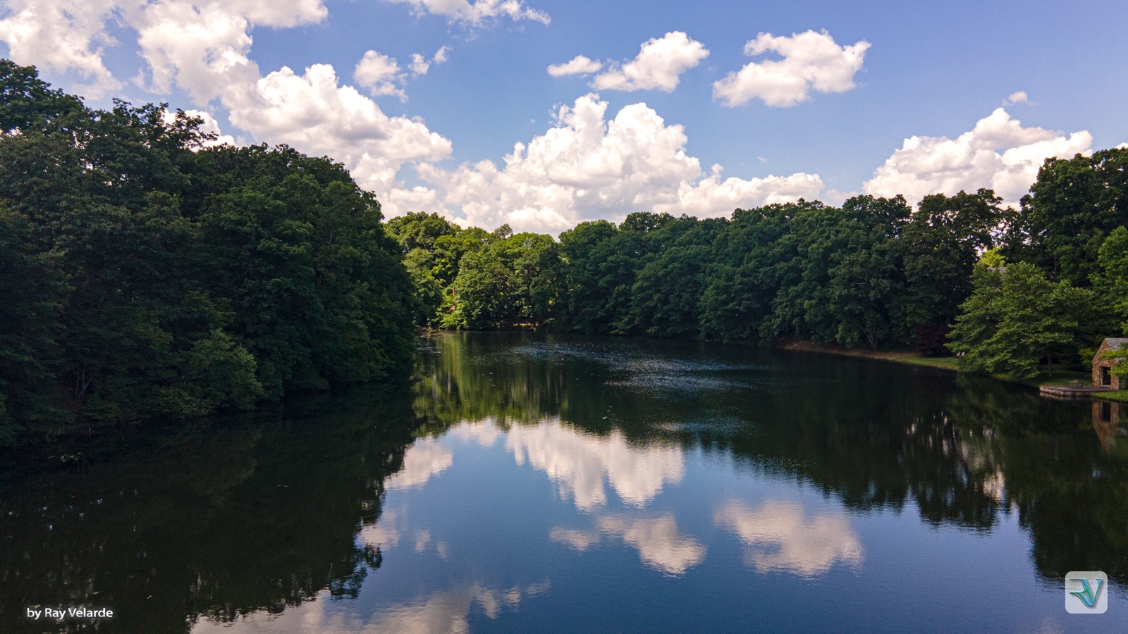 Forest and summer clouds reflected in a calm lake