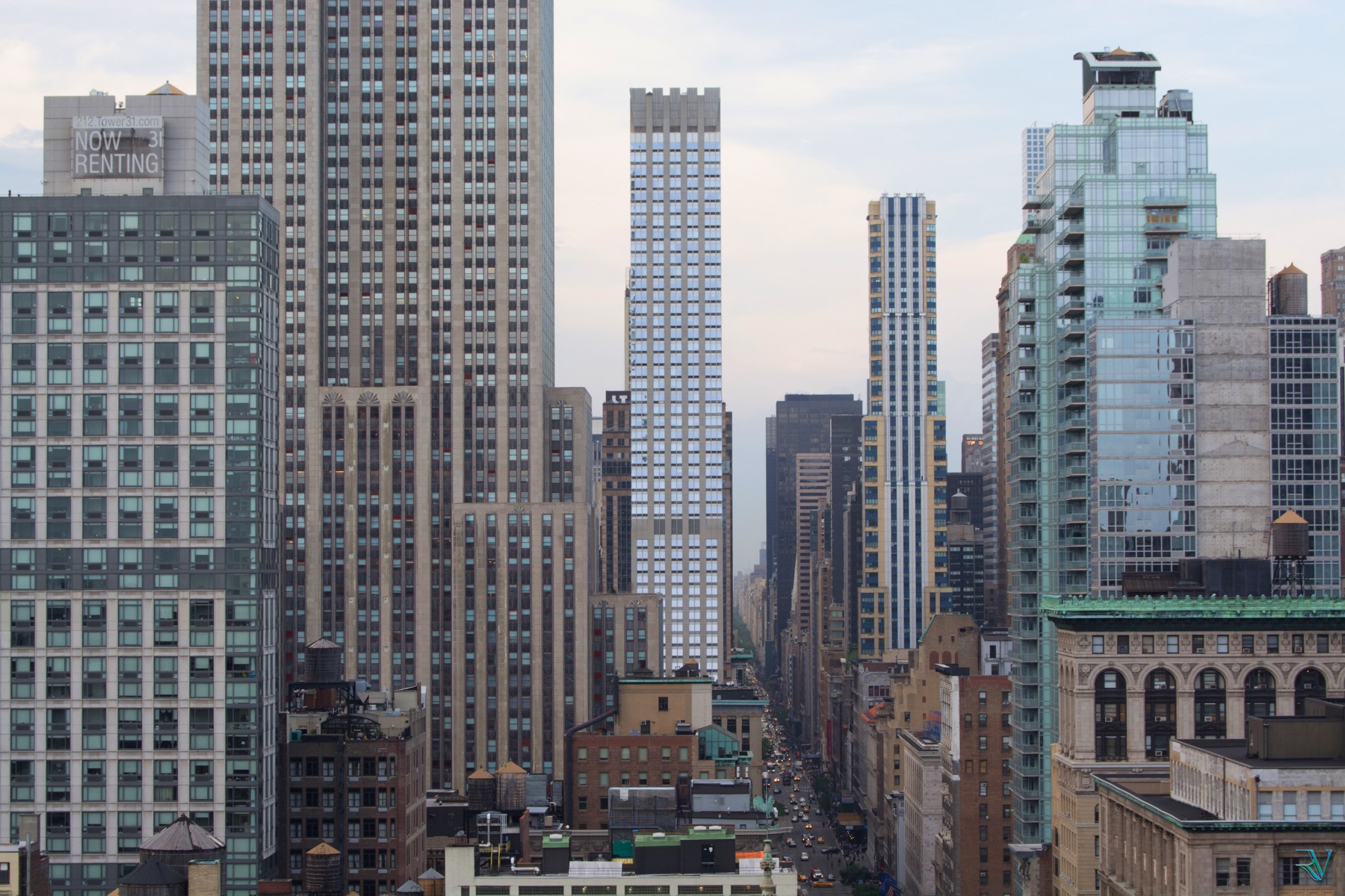 A Manhattan avenue running between layers of tall buildings