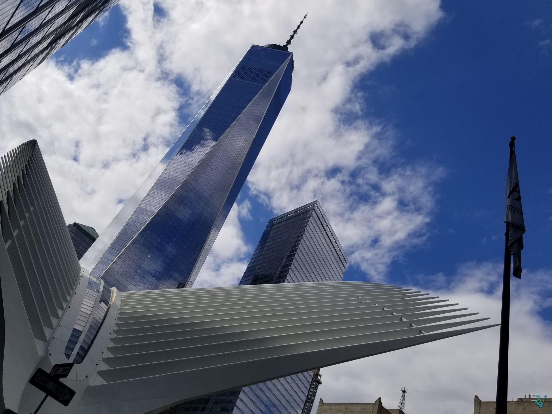 One World Trade Center and the Oculus rising into a blue, cloud-filled sky