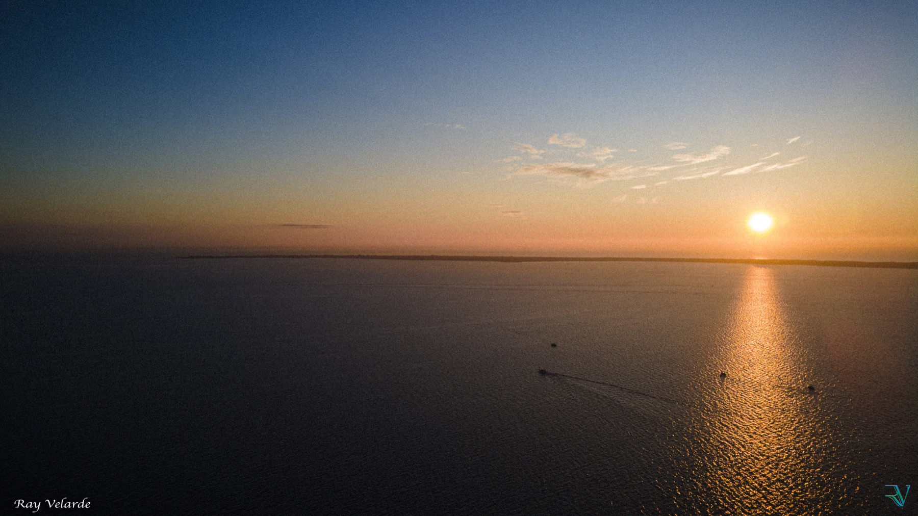 Warm sunset casting a long golden reflection across open water