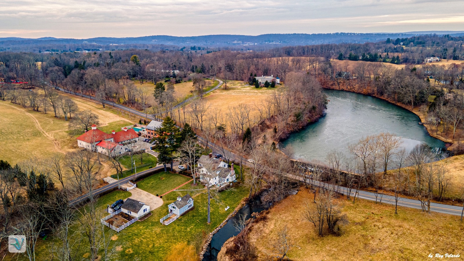 Aerial winter view of an estate, pond, roads, and bare countryside